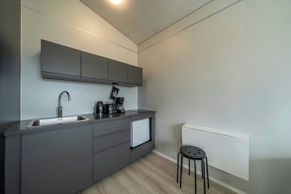 Een moderne keuken met een inbouwvaatwasser, een spoelbak en een koffiezetapparaat.