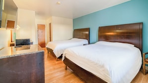 A hotel room with two beds, a desk, and a mirror. - American Inn by OYO Colorado City I-20 (Colorado City)