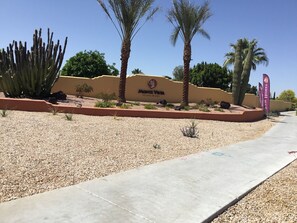A desert landscape with a sign for Monte Vista Village Resort. - Monte Vista Resort-Age 55 Plus (Mesa)