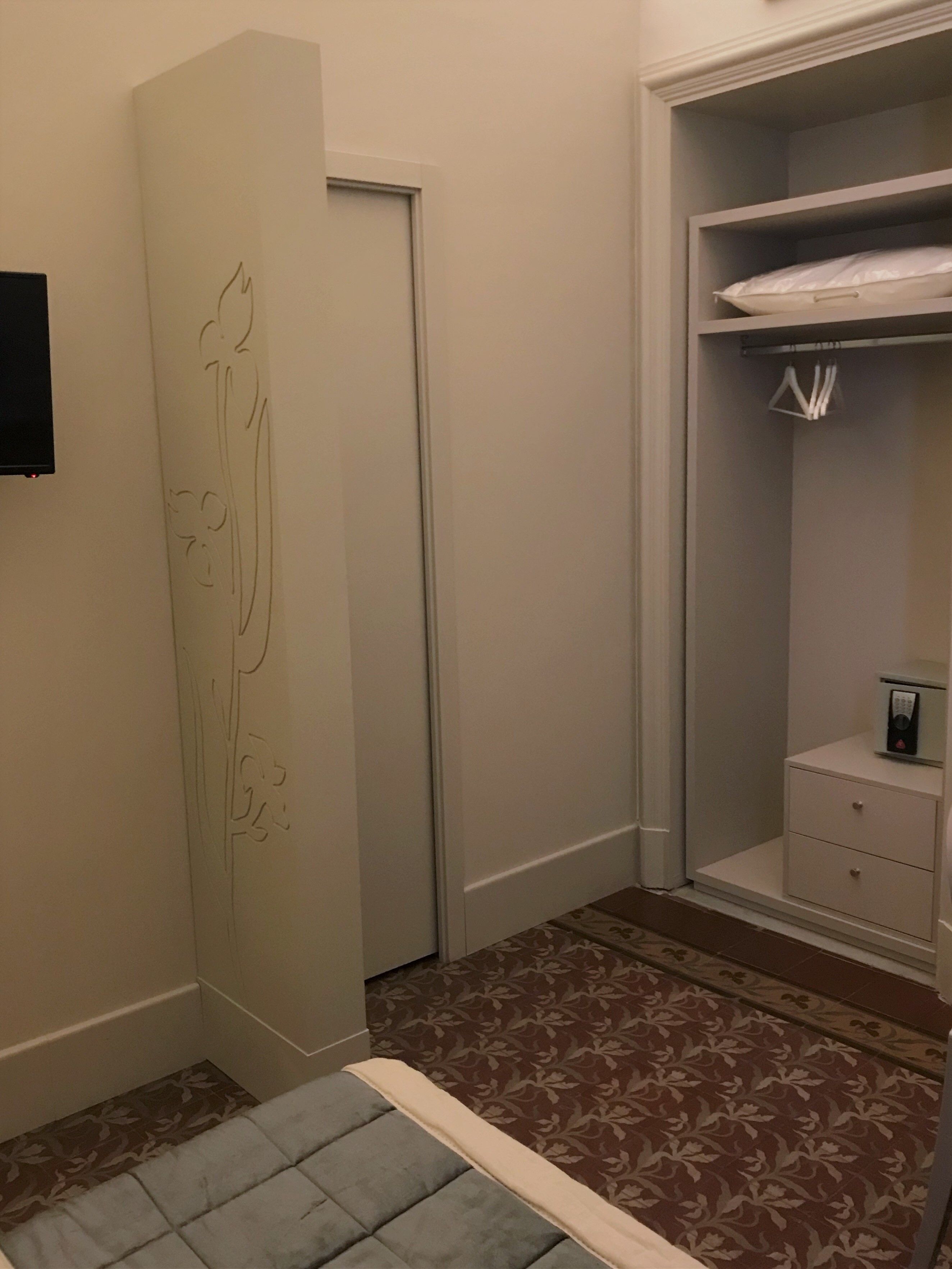 A bedroom with a bed, a wardrobe, a bedside table, and a nightstand.