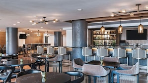 A modern bar area with round tables, bar stools, and hanging pendant lights. - Fairfield Inn & Suites by Marriott Dallas Downtown (Dallas)
