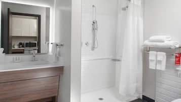 A modern bathroom with a shower, toilet, and sink.