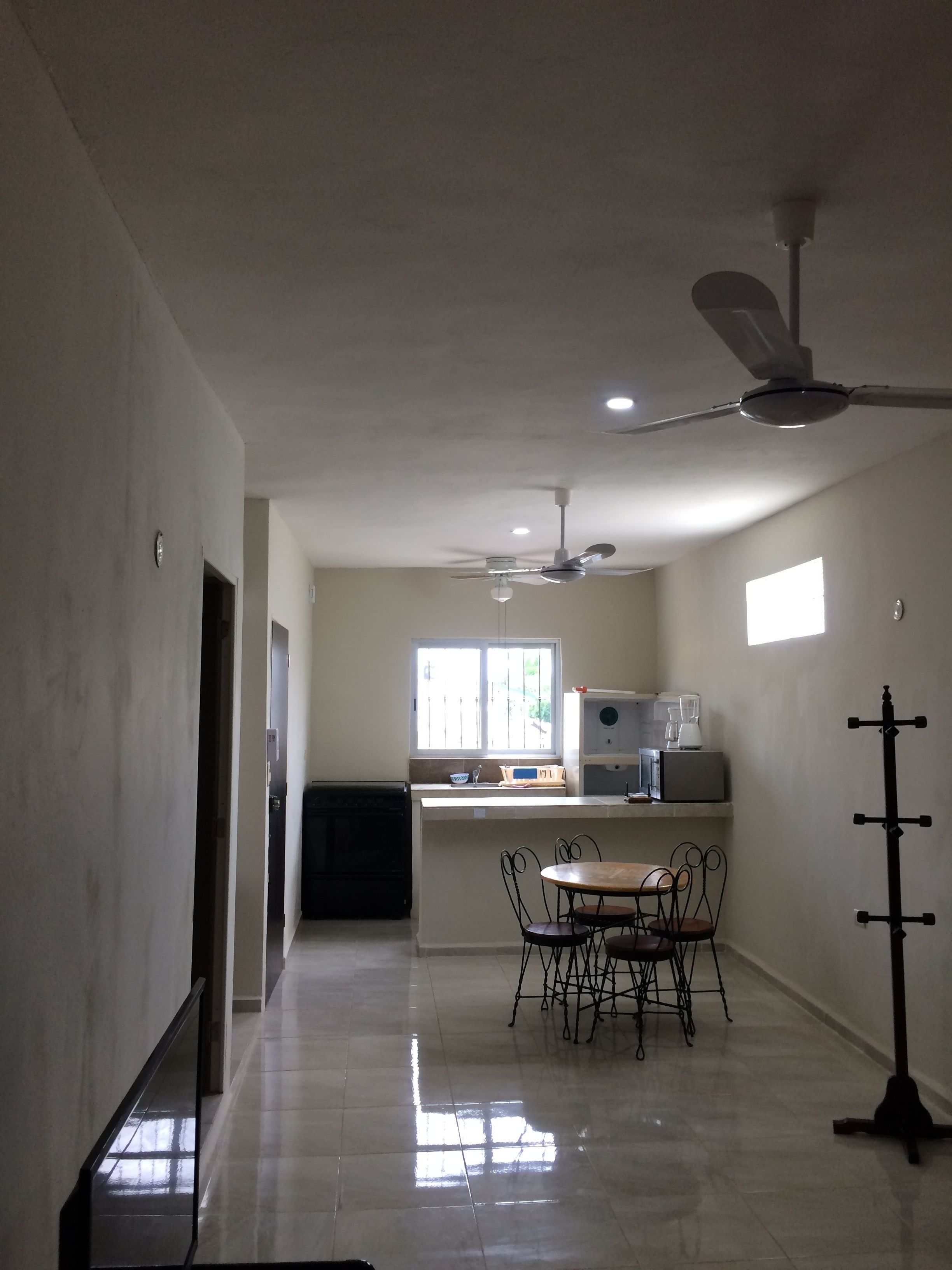 A spacious kitchen with a dining area, a ceiling fan, and a window providing natural light.