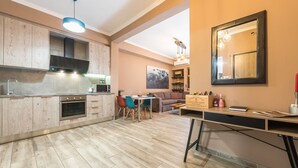 A modern kitchen with wooden cabinets, a dining area with a table and chairs, and a large mirror on the wall. - Stylish Luxury Apartment near Acropolis at Neos Kosmos metro station  (Neos kosmos)