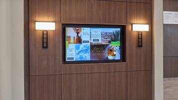 Una pared de pantallas digitales con diversos anuncios e información.