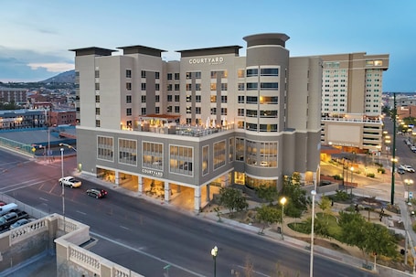 Un hotel Courtyard by Marriott con diseño moderno, varios pisos y un estacionamiento.