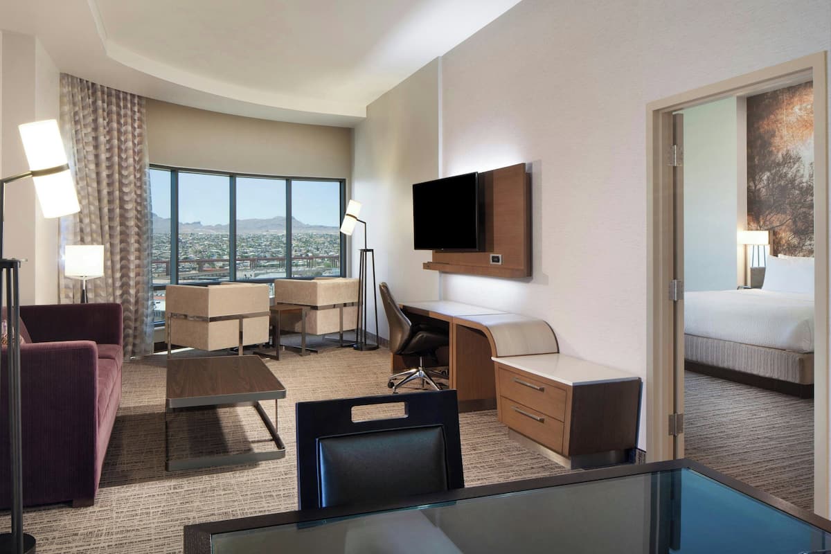 Ein Hotelzimmer mit Schreibtisch, Stuhl, Sofa und einem Bett.