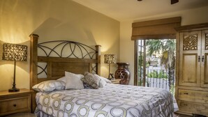 Une chambre à coucher avec un grand lit, deux lampes de chevet, une tête de lit en bois, une table de chevet et une armoire.