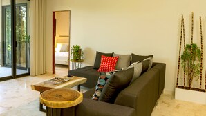 A modern living room with a sofa, a coffee table, and a side table. There is a sliding glass door leading to a balcony. - Depto en Cancun 506 by Sinbad (Cancun)