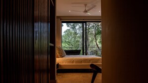 A bedroom with a large window, a bed, and a chair. - Depto en Cancun 506 by Sinbad (Cancun)