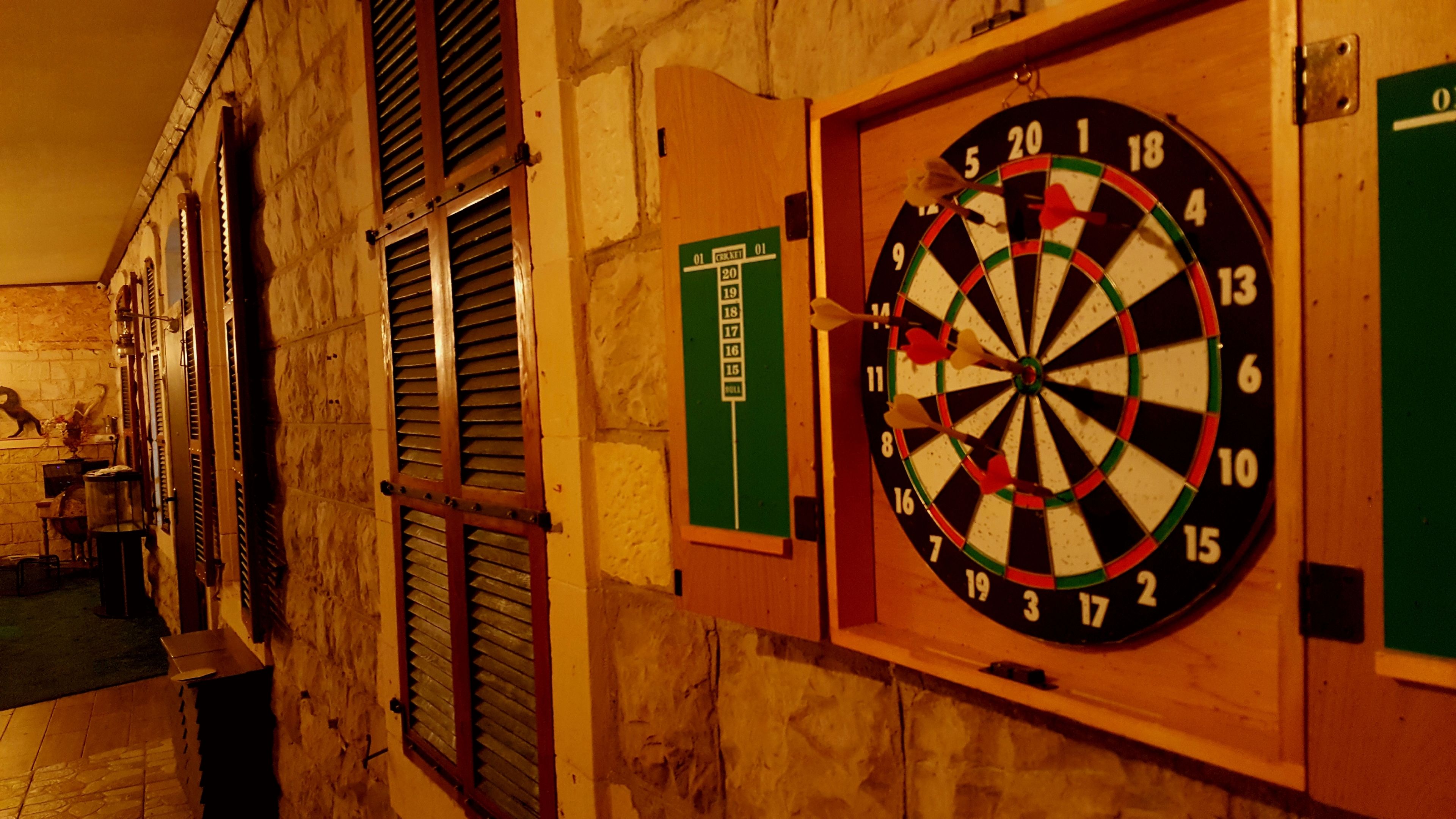A dartboard mounted on a wall with a green sign above it.