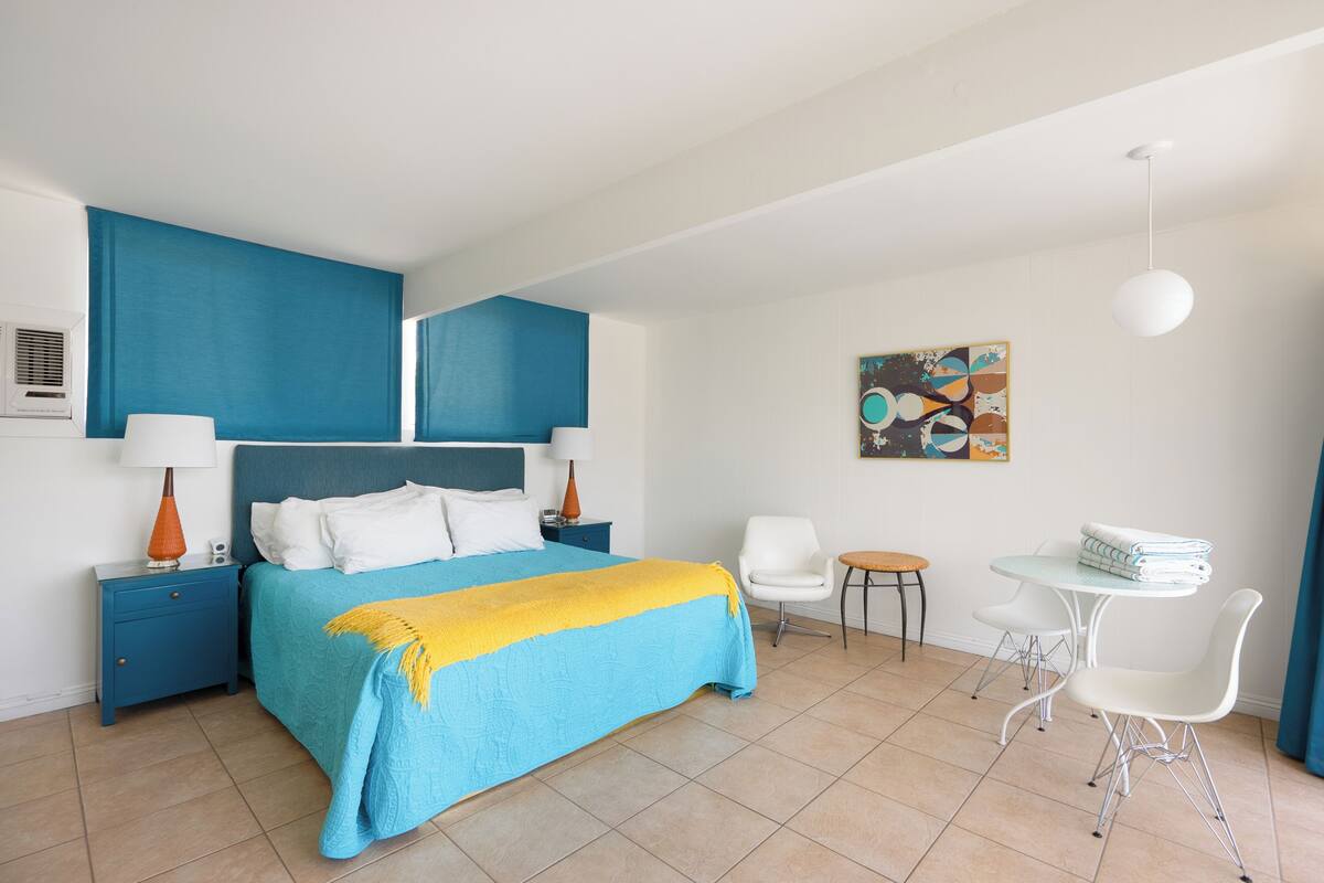 Ein modernes Hotelzimmer mit einem großen Bett, einem Schreibtisch und einem Sessel.