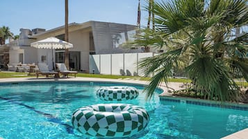 Relax by the pool surrounded by lounge chairs and umbrellas in a comfortable outdoor space.