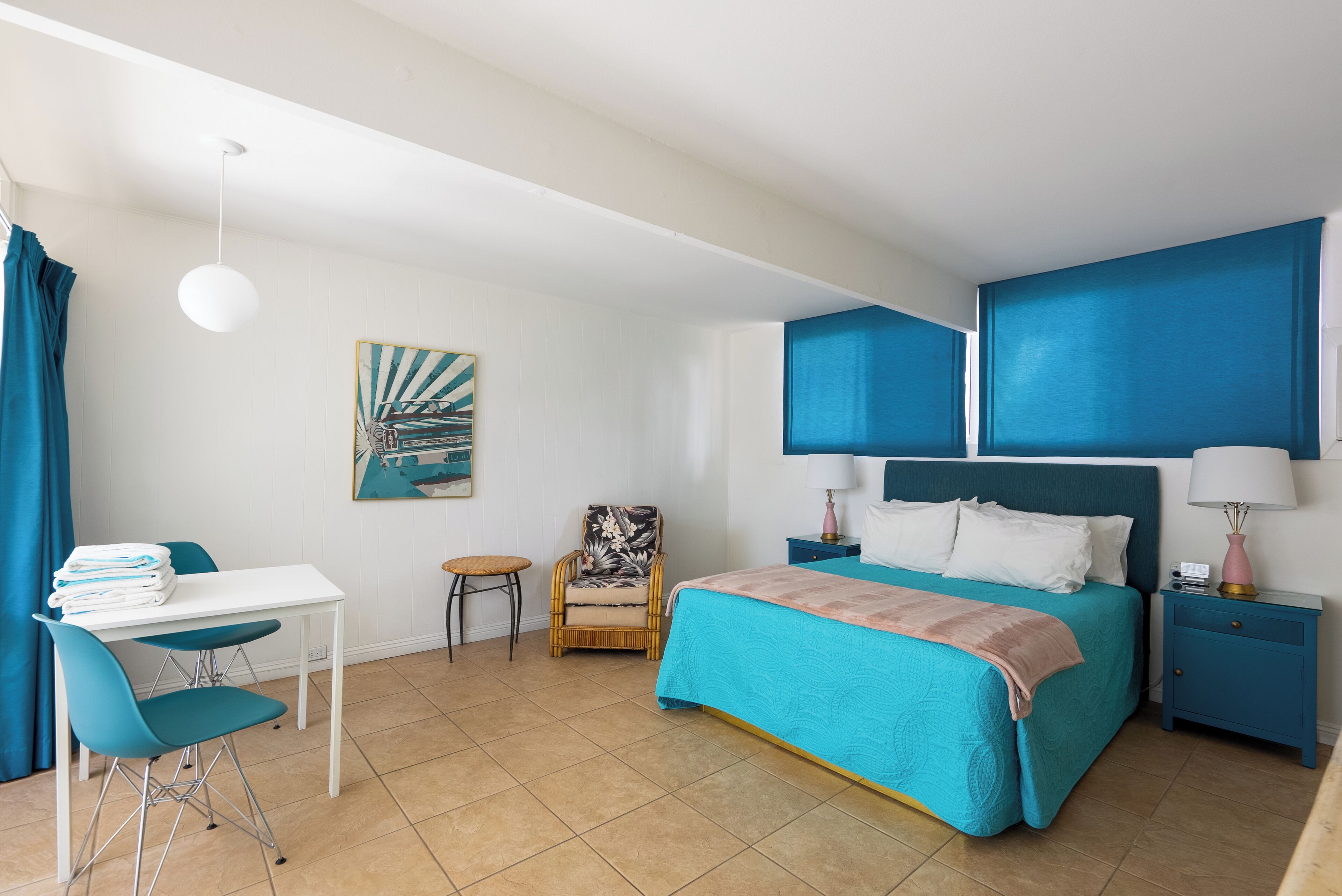 Une chambre à coucher avec un lit, un bureau, une chaise et une petite table.