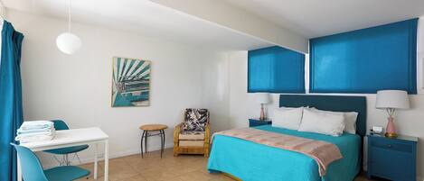 Une chambre à coucher avec un lit, un bureau, une chaise et une petite table.