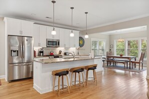 Enjoy cooking in this well-equipped kitchen with a large island, central sink, and stainless steel appliances.