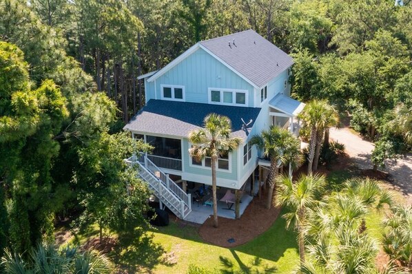 A light blue two-story house with a covered porch and a staircase leading to the upper level.