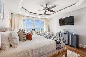 A bedroom with a bed, a ceiling fan, a TV, a dresser, and a view of the ocean. - 6 BR + Bonus Room, Luxury Oceanfront, Pets ok, Elevator, 2 Living Rooms - The Loggerhead (Folly Beach)