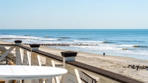 A beach view with a wooden deck, a sandy beach, and the ocean. - 6 BR + Bonus Room, Luxury Oceanfront, Pets ok, Elevator, 2 Living Rooms - The Loggerhead (Folly Beach)