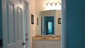 A hallway leading to a bathroom with a sink, mirror, and light fixture. - 3 Bedroom Home with Heated Private Pool Close to Golf & Beach (Rotonda lakes)