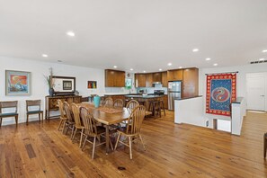 A spacious kitchen with wooden cabinets, a dining area with a large table and chairs, and a kitchen island.