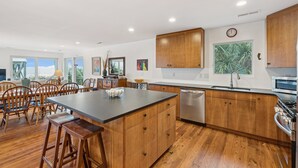Una cucina moderna con mobili in legno, una grande isola e vista sull'esterno.