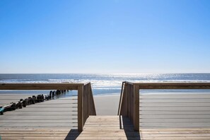 Walk along the boardwalk to the wide, open beach with a clear view of the ocean.