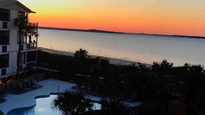 Ein Resort mit Swimmingpool und Blick auf das Meer bei Sonnenuntergang.