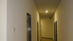 A long, narrow hallway with doors on both sides, leading to individual rooms. - Hotel Wawasan (Simpang Renggam)