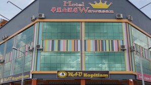 A hotel with a modern facade, featuring large windows and a colorful striped design. - Hotel Wawasan (Simpang Renggam)