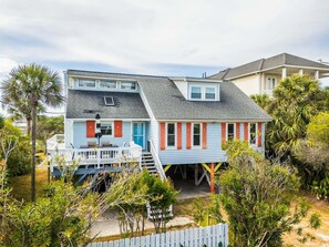 A two-story house with a porch, a small deck, and a fenced yard.