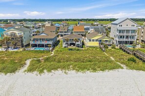 A coastal residential area with houses, a swimming pool, and a beach.