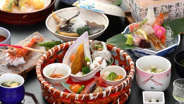 A variety of Japanese dishes arranged on a table, including sushi, sashimi, and other seafood items. - Umisanpo (Ofunato)