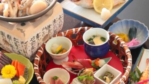 A variety of seafood dishes, including fish, shrimp, and other seafood, served on a table with multiple bowls and plates. - Umisanpo (Ofunato)
