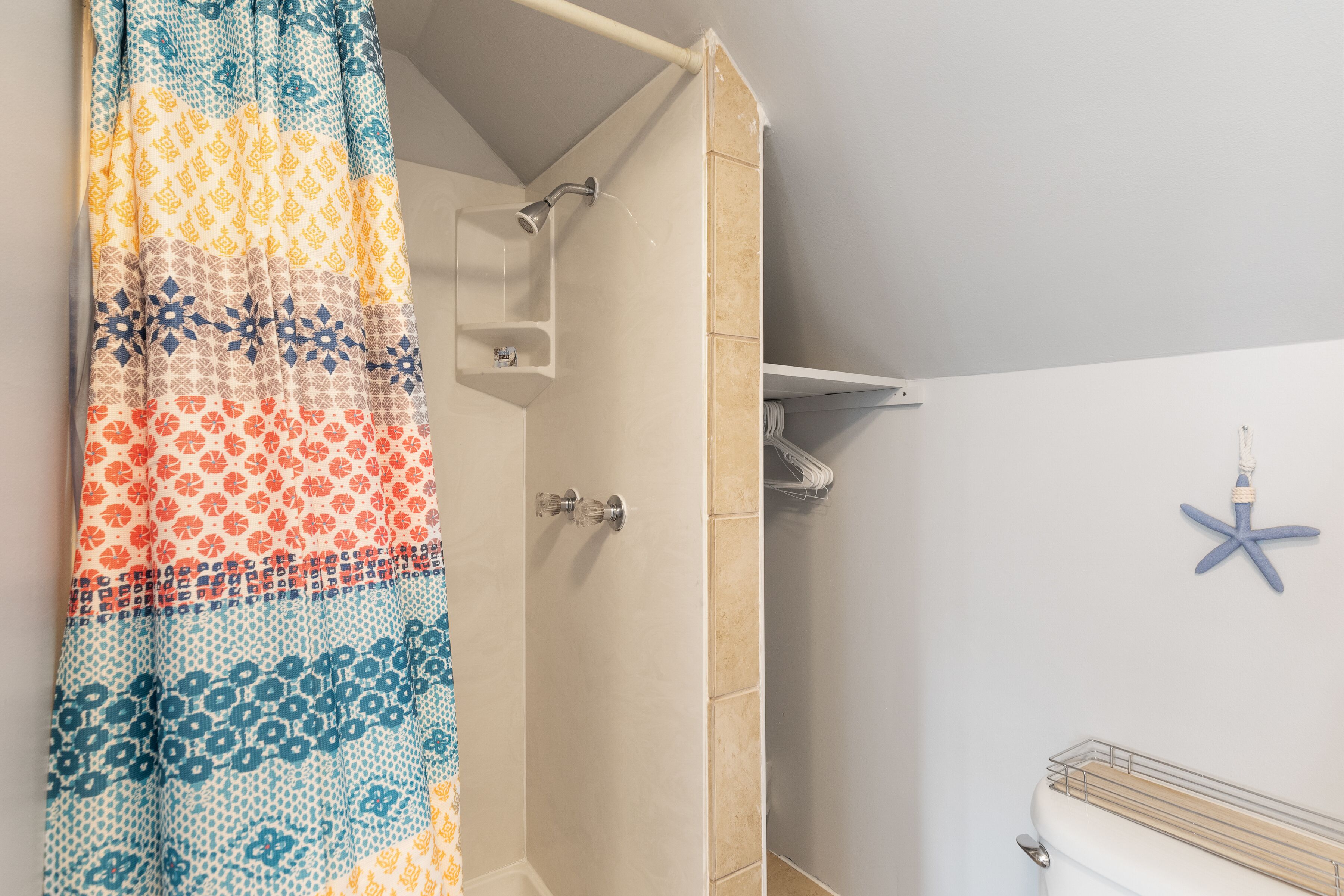 Une salle de bain avec une douche, des toilettes et un porte-serviettes.