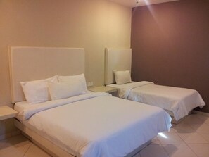 A hotel room with two single beds, a nightstand, and a mirror. - SR Inn (Simpang Renggam)