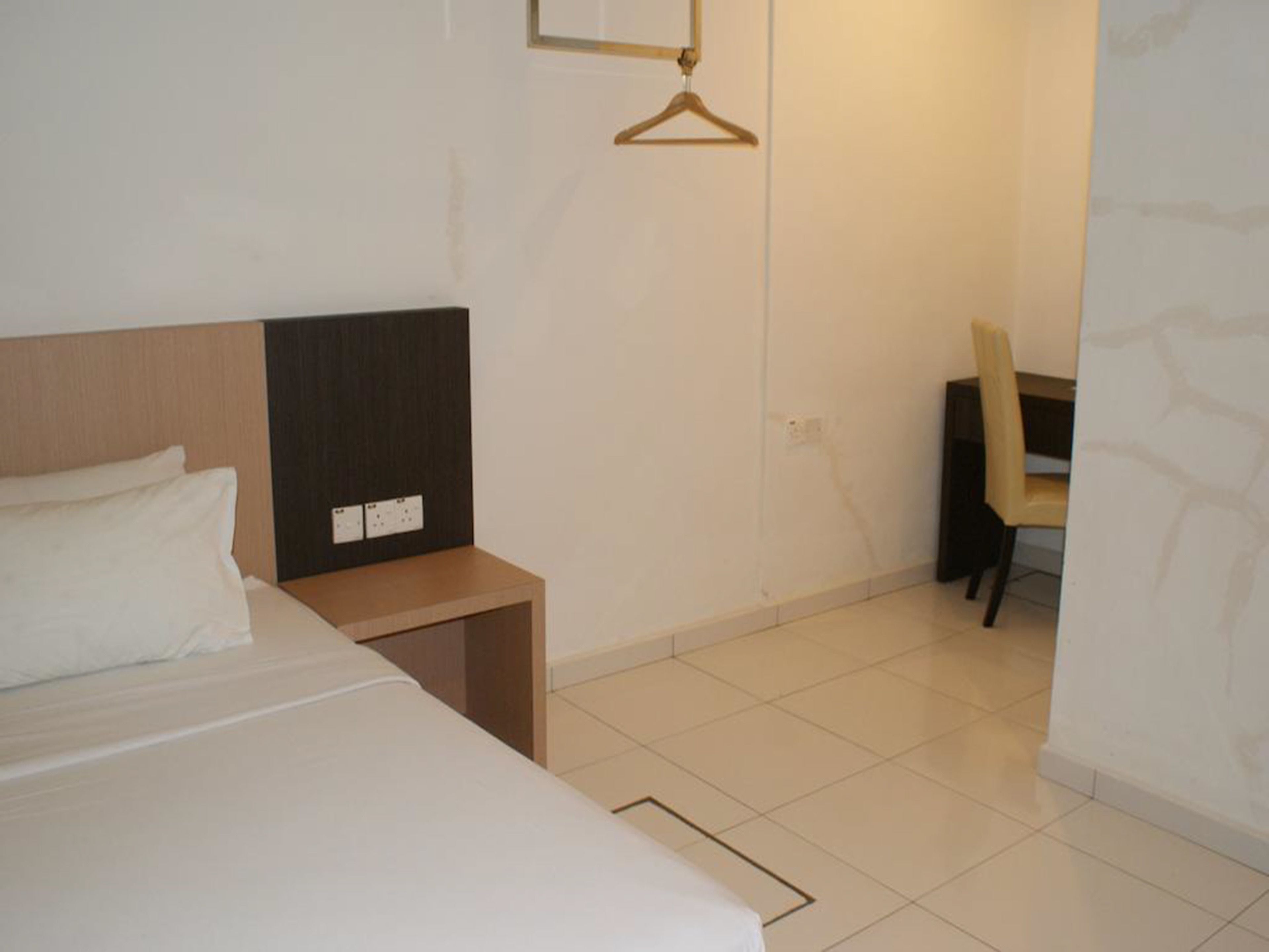 A hotel room with a bed, a desk, and a chair.