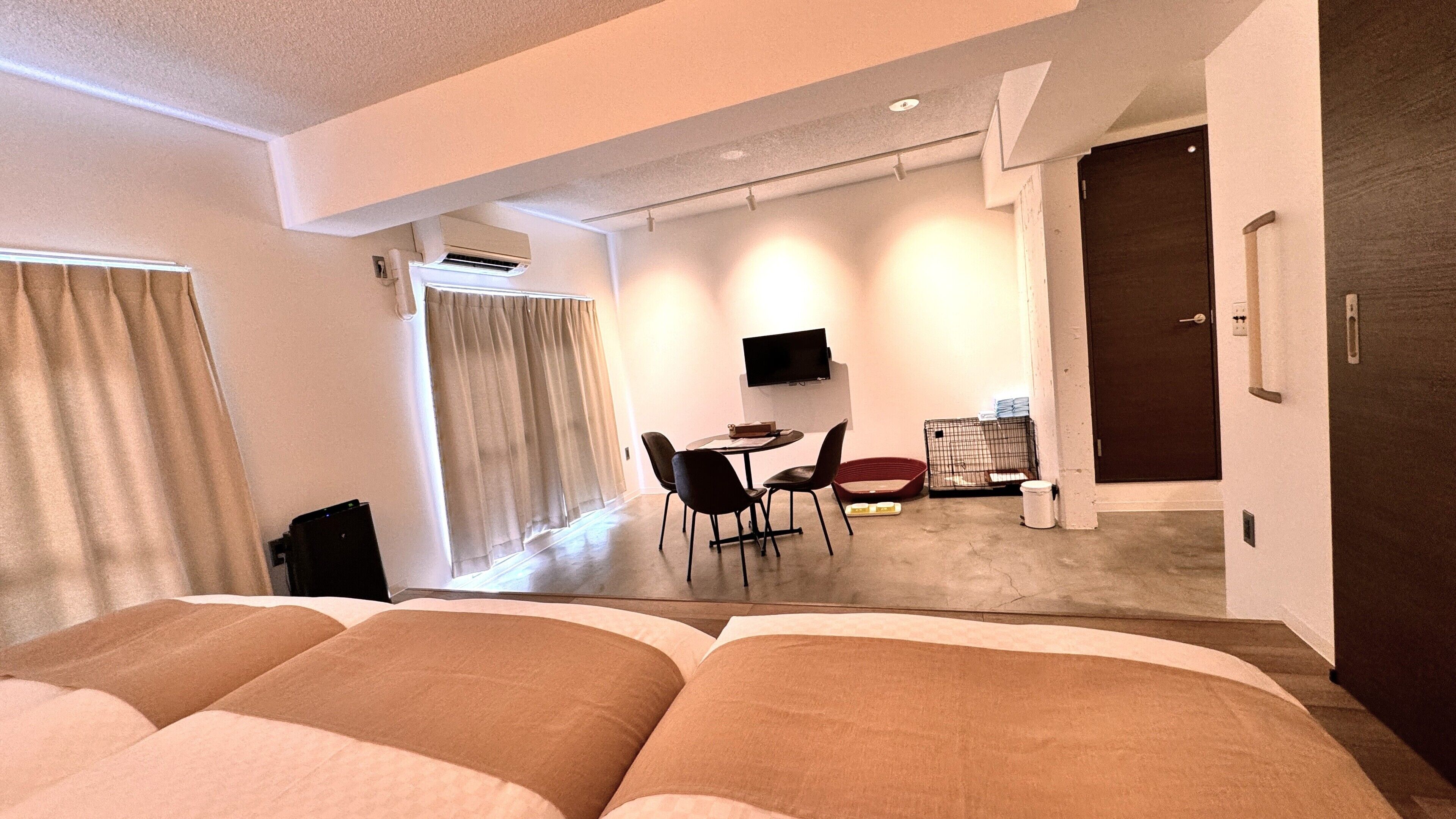 Una habitación de hotel con cama, escritorio, silla, televisor y puerta.