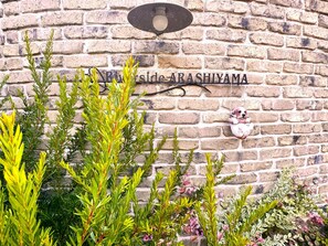 A brick wall with a sign reading "Riverside Arashiyama".