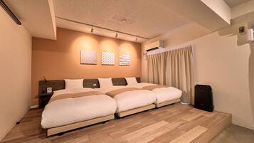 Une chambre d’hôtel moderne avec un grand lit, un plancher en bois et un plafond doté d’un éclairage encastré.