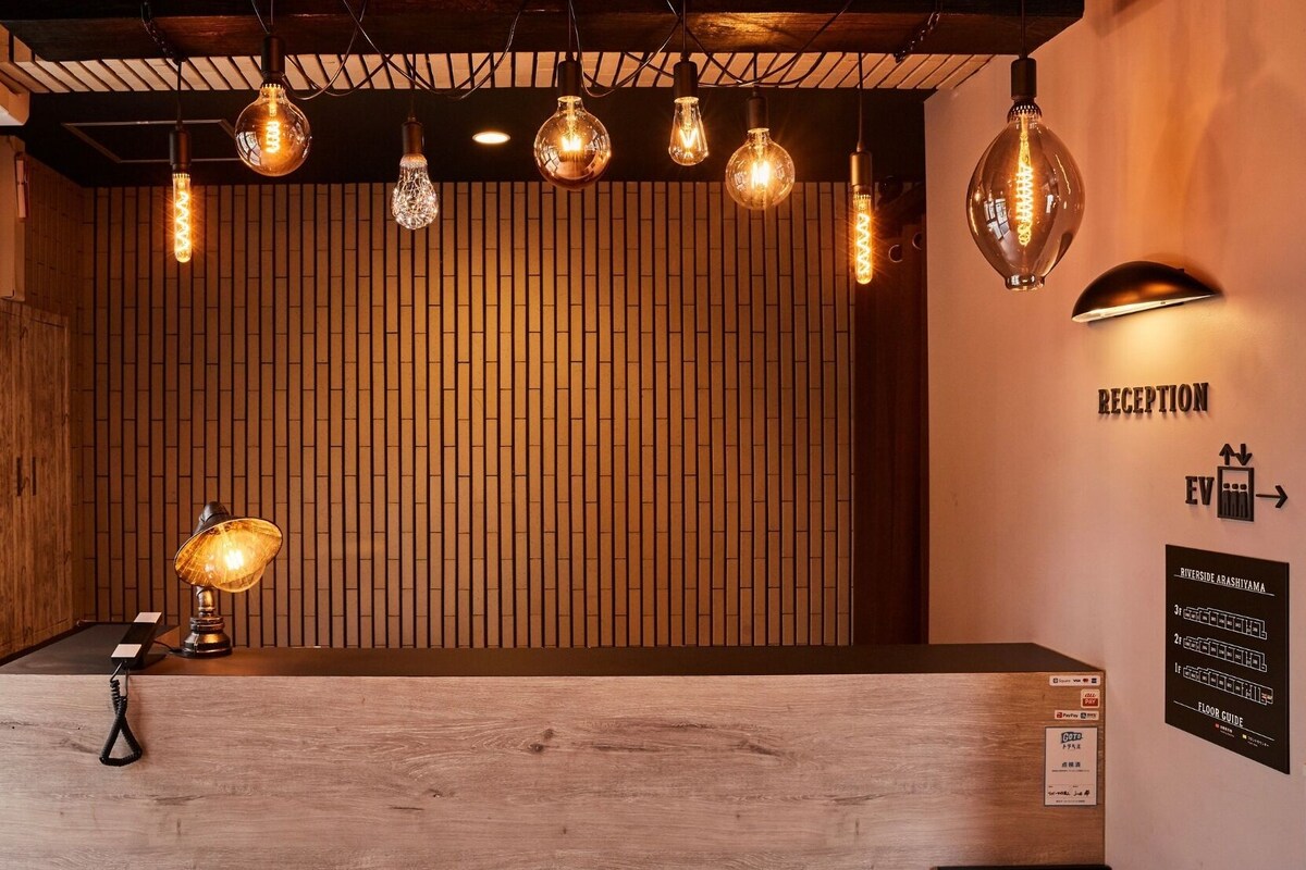 A reception area with a wooden reception desk, hanging pendant lights, and a floor guide sign.