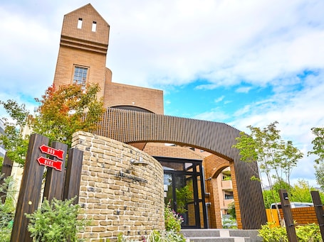 A building with a brick facade, a tower, and a sign indicating directions for dog and bike access.