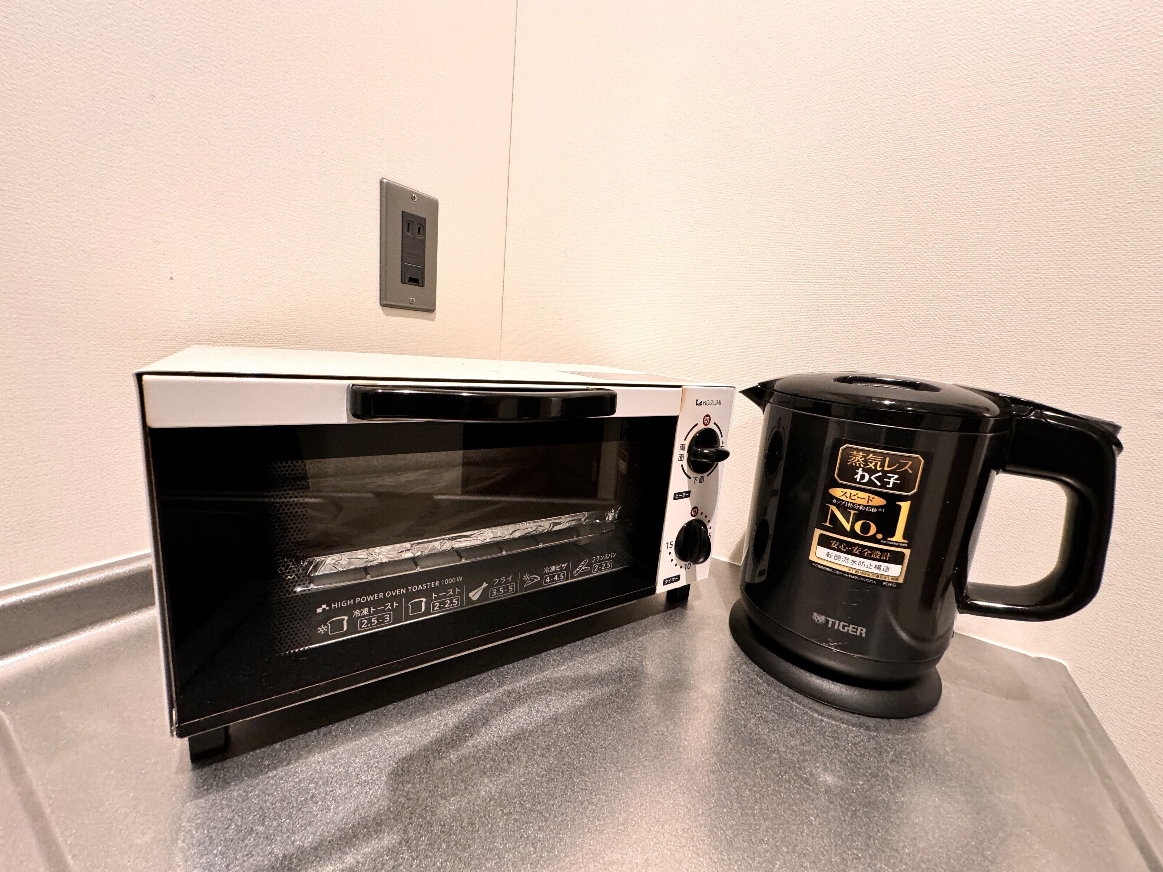 A kitchen with a black toaster oven and a black electric kettle on the counter.