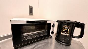 A kitchen with a black toaster oven and a black electric kettle on the counter.