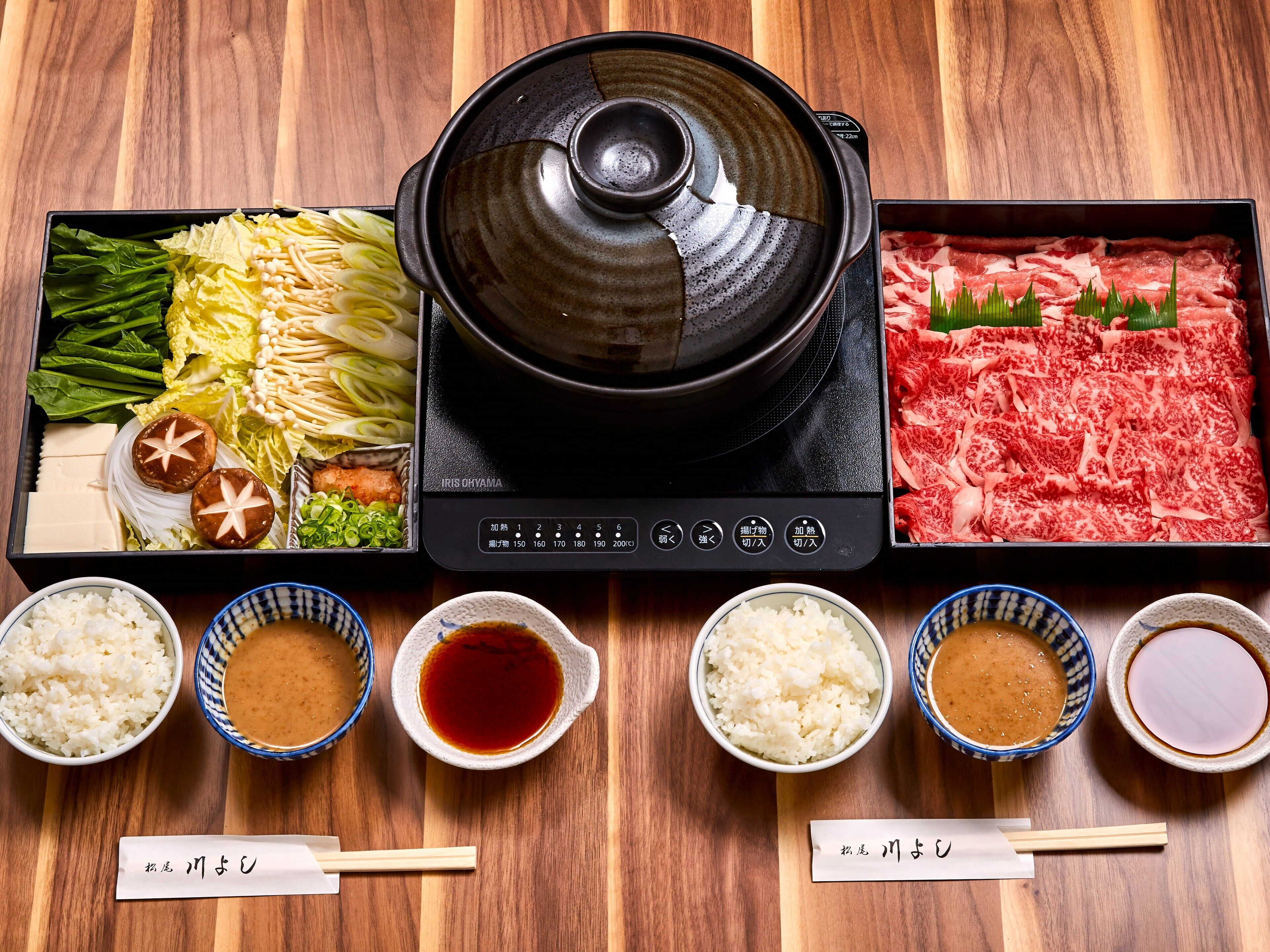 A hot pot setup with various ingredients and condiments.