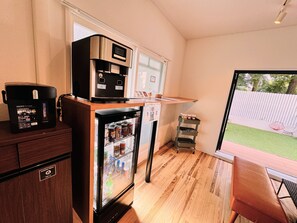 A compact kitchen with a coffee machine, refrigerator, and a small cart with jars. - Riverside Arashiyama (Kyoto)