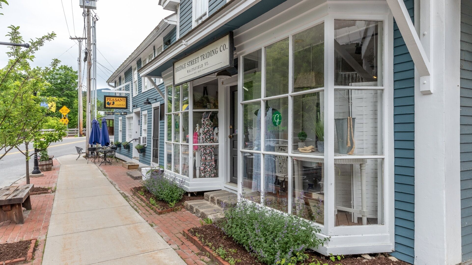 A storefront with a sign reading "Bridge Street Trading Co." and a "Peasant" sign above it.
