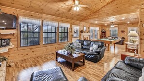 A cozy cabin interior with wooden walls, a pool table, leather sofas, and a television. - Inspiration Point 1 Bedroom 1 Bathroom Cabin (Sevierville)