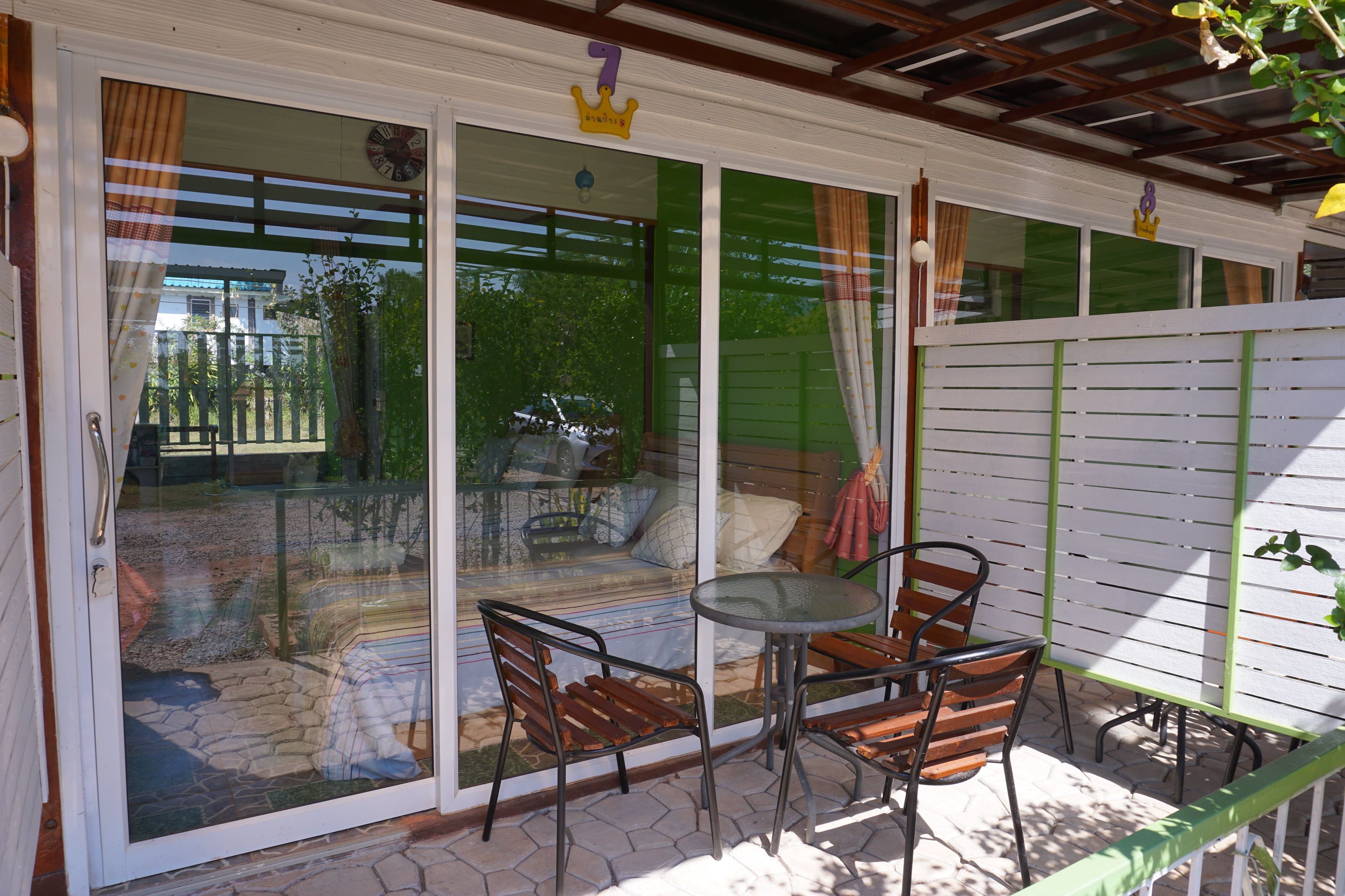 A patio with a glass door, a small round table, and two wooden chairs.