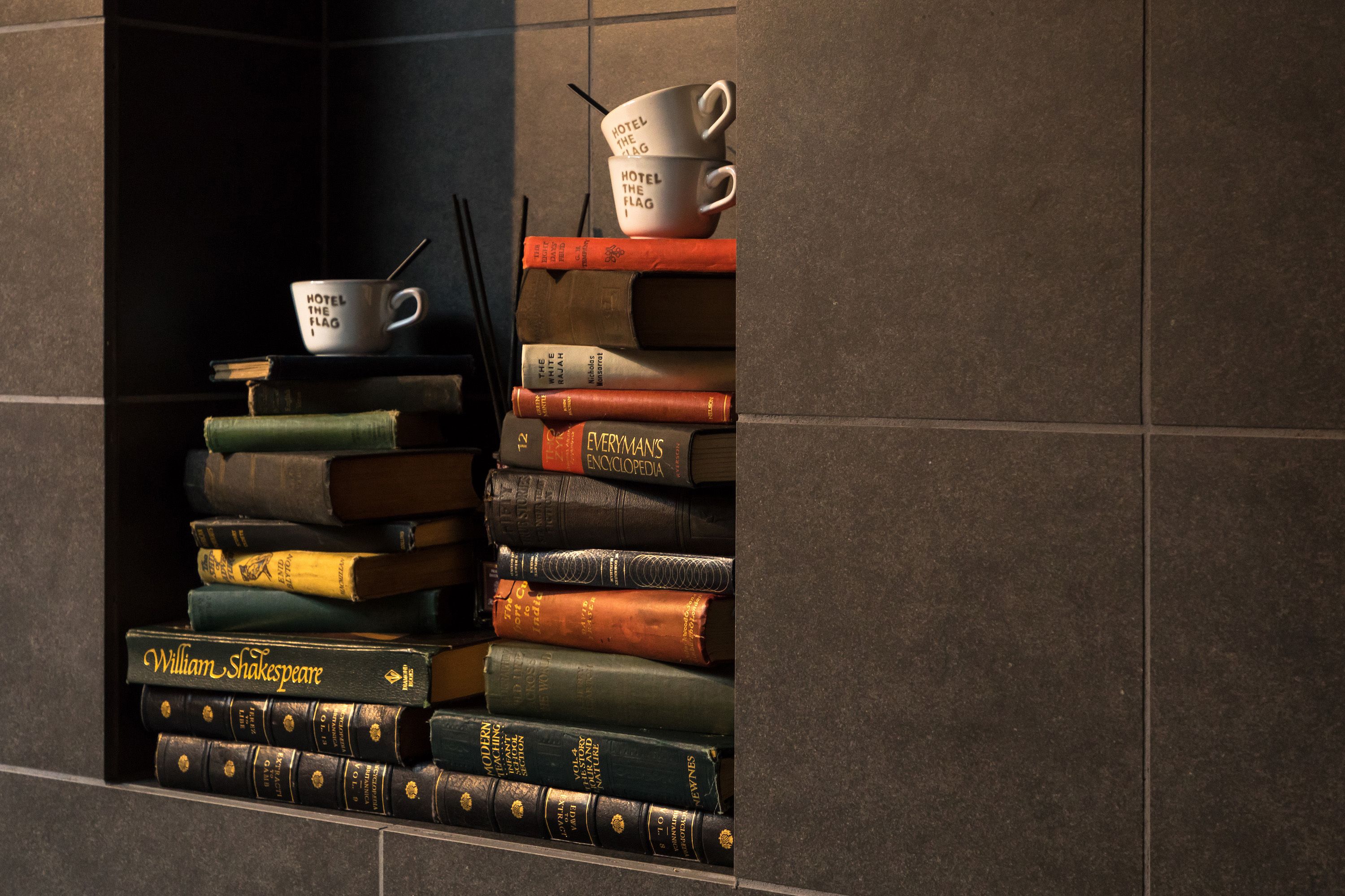 A stack of books with a coffee cup on top.